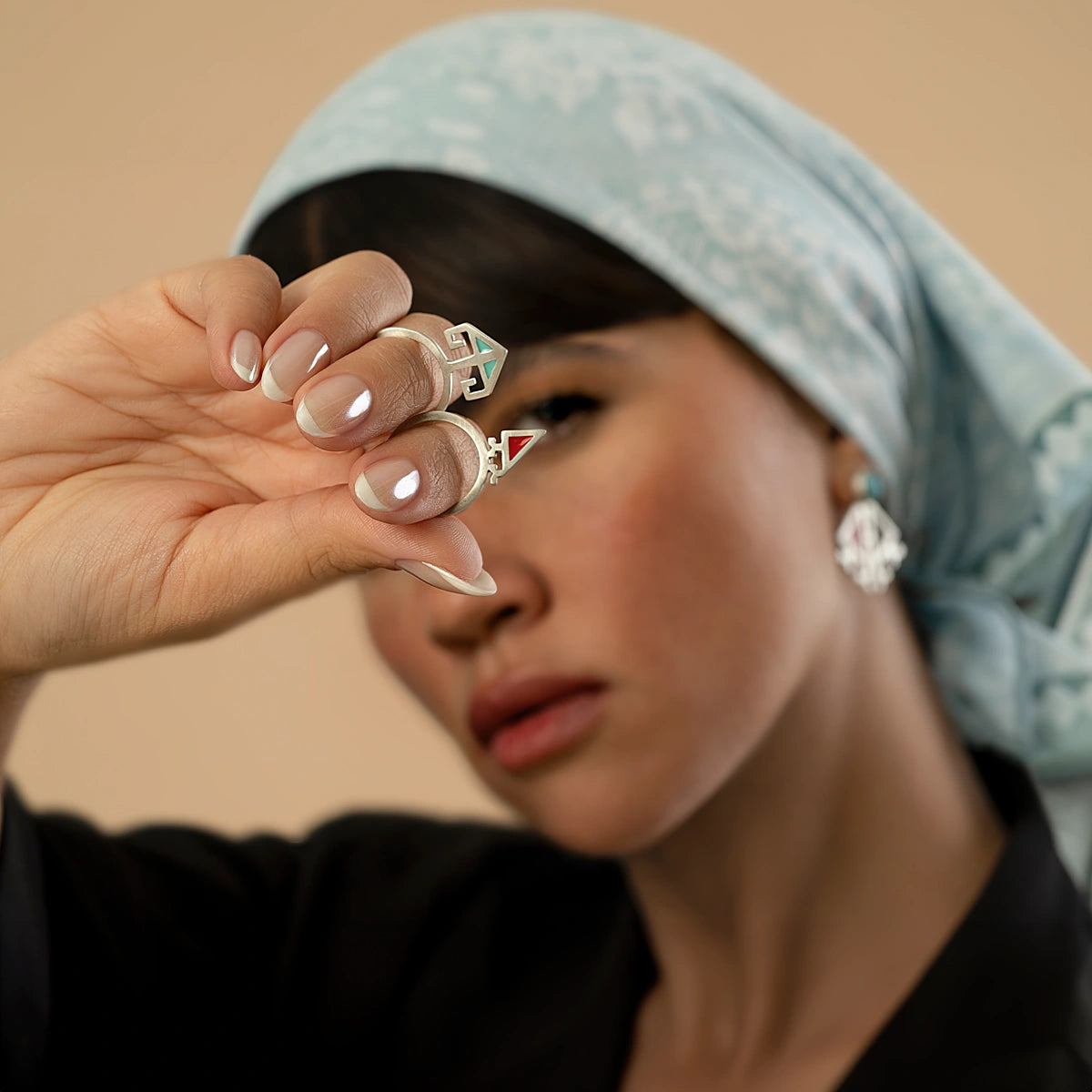 model wearing handmade minimalist matching silver rings with blue and red enamel