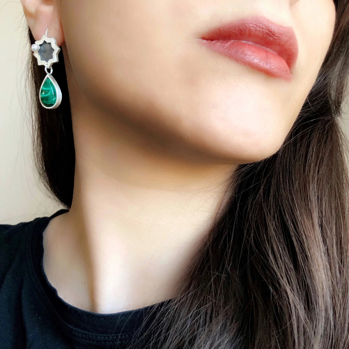 model wearing handmade silver star drop earrings with malachite and pearl