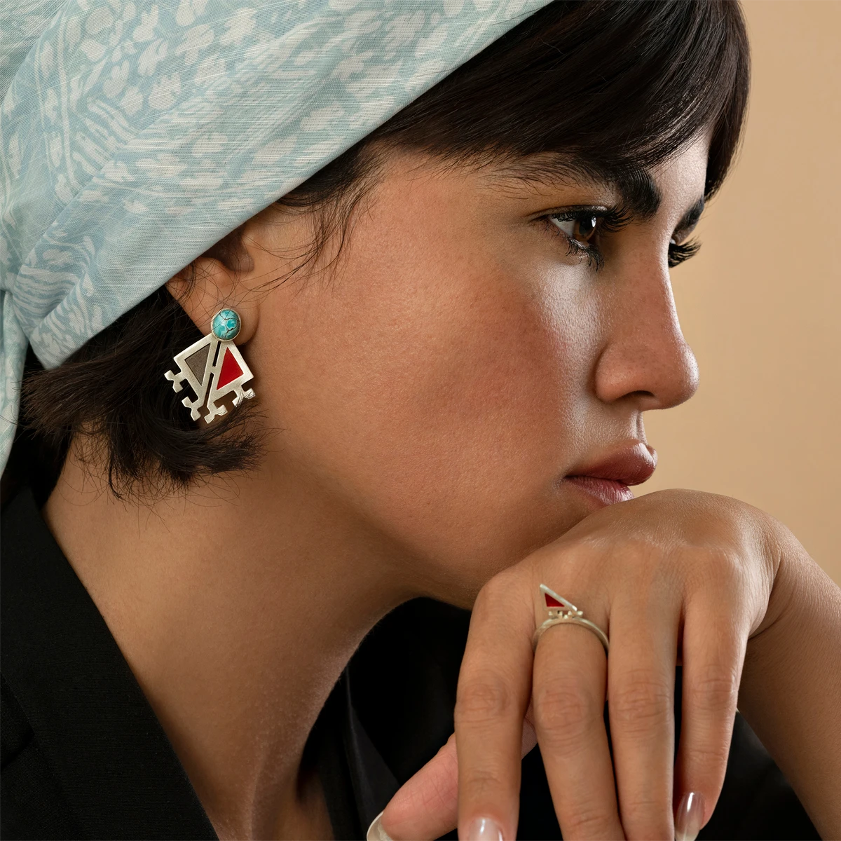 model wearing handmade triangular silver and enamel earrings decorated with Persian turquoise