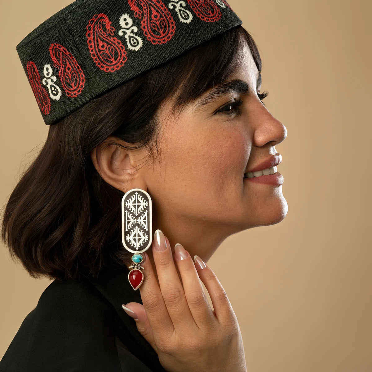model wearing handmade oxidized silver drop earrings with geometric pattern decorated with turquoise and red onyx