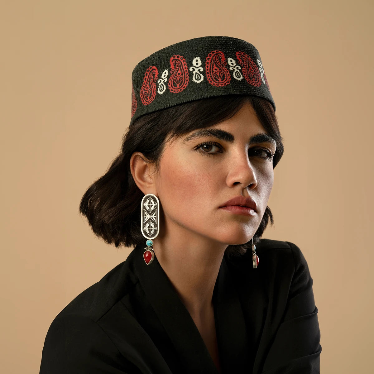 model wearing handmade oxidized silver drop earrings with geometric pattern decorated with turquoise and red onyx