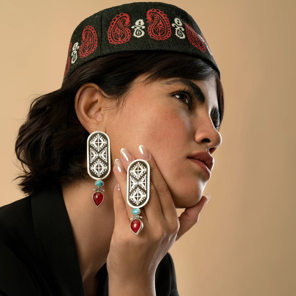 model wearing handmade oxidized silver drop earrings with geometric pattern decorated with turquoise and red onyx
