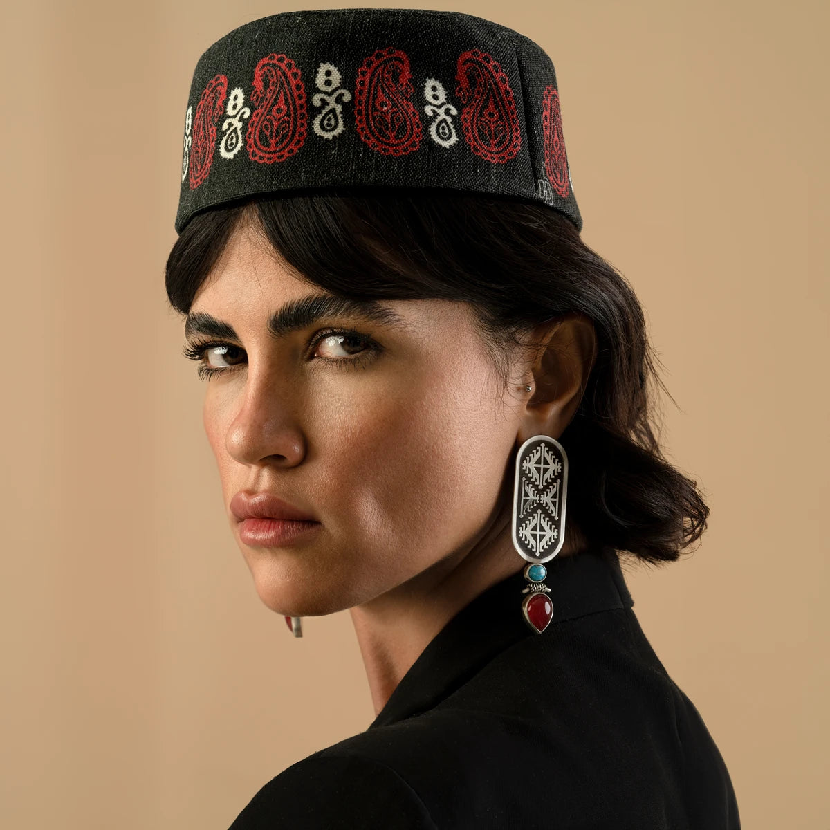 model wearing handmade oxidized silver drop earrings with geometric pattern decorated with turquoise and red onyx