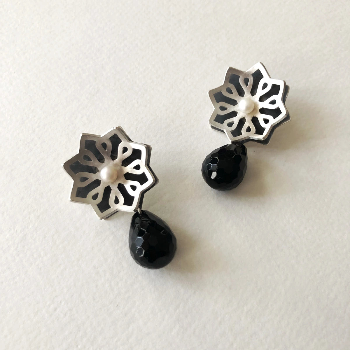 handmade silver star-shaped earrings with pearl and faceted onyx