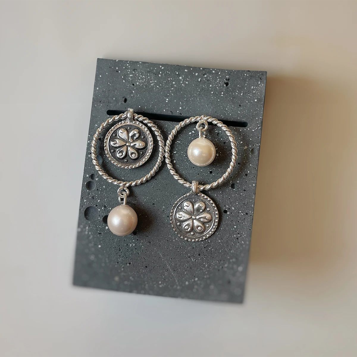 Handmade mismatched silver dangle earrings with rope-textured circles, faux pearls, and oxidized floral medallion design