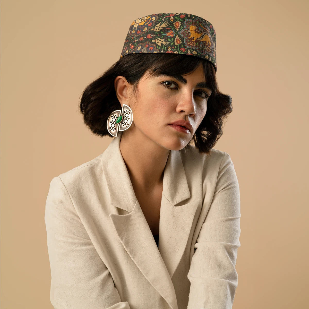 model wearing handmade openwork oxidized silver statement earrings in the shape of 2 half-circles with malachite