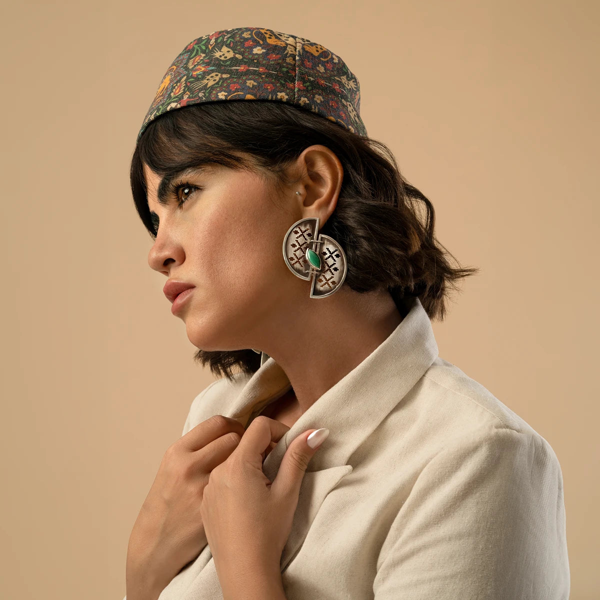 model wearing handmade openwork oxidized silver statement earrings in the shape of 2 half-circles with malachite
