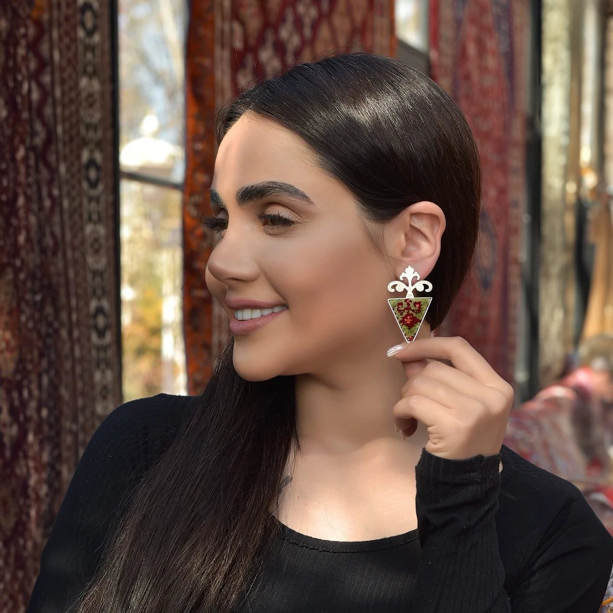 model wearing handmade silver drop statement earings with Persian rug decoration