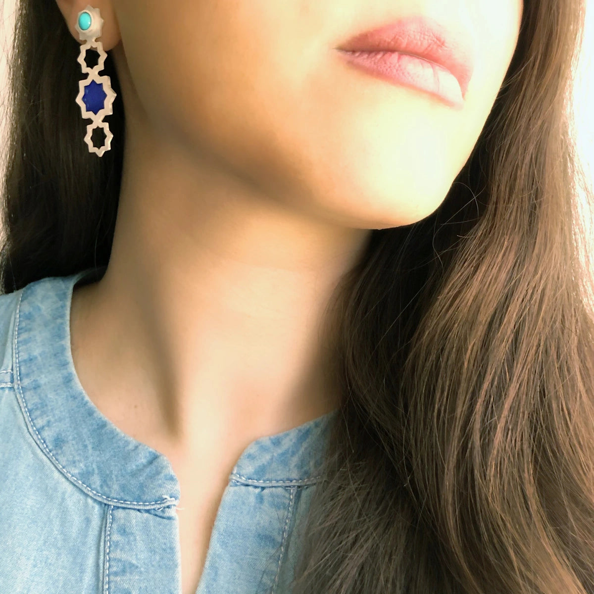 model wearing handmade openwork silver and blue enamel statement stars earrings with turquoise