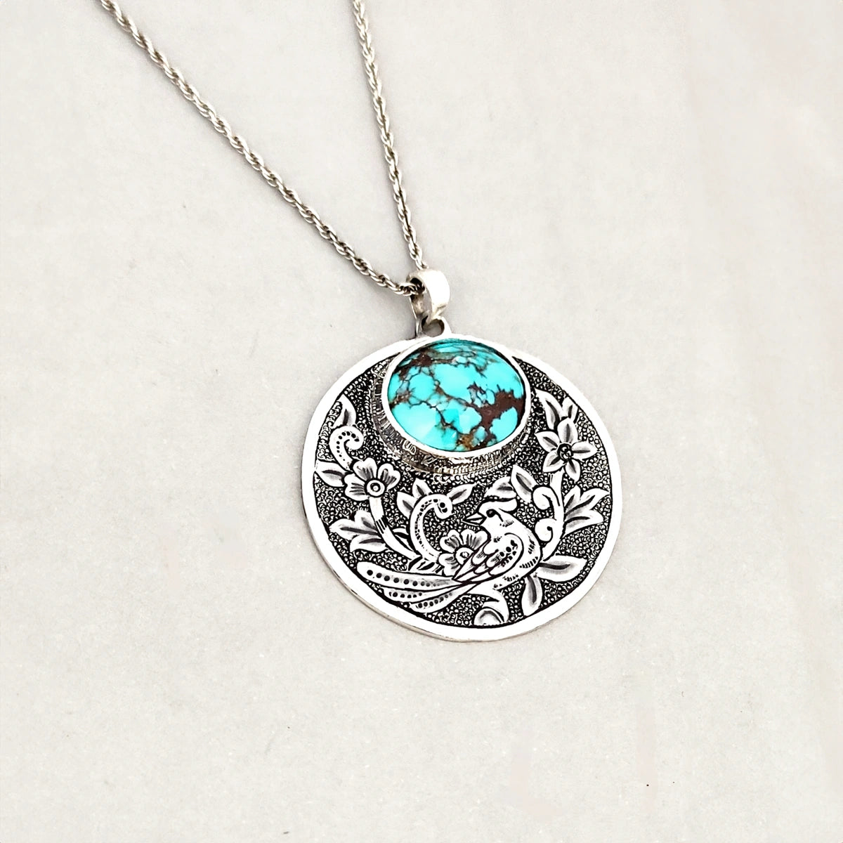 hand-engraved silver medallion necklace with floral motifs and Persian turquoise