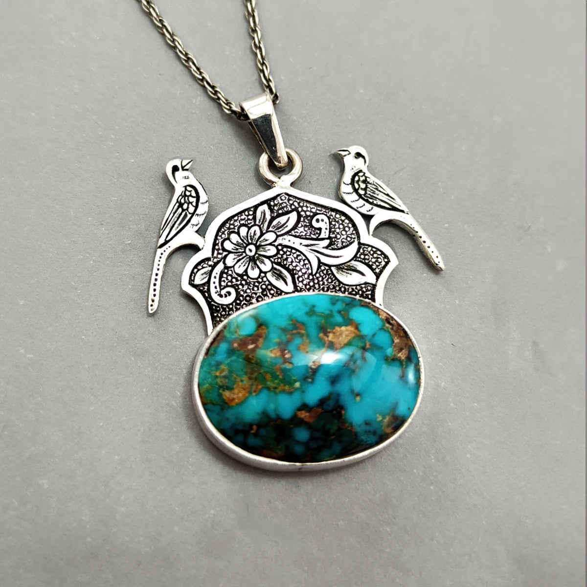 hand-engraved silver pendant necklace decorated with floral crown with birds and oval Persian Turquoise