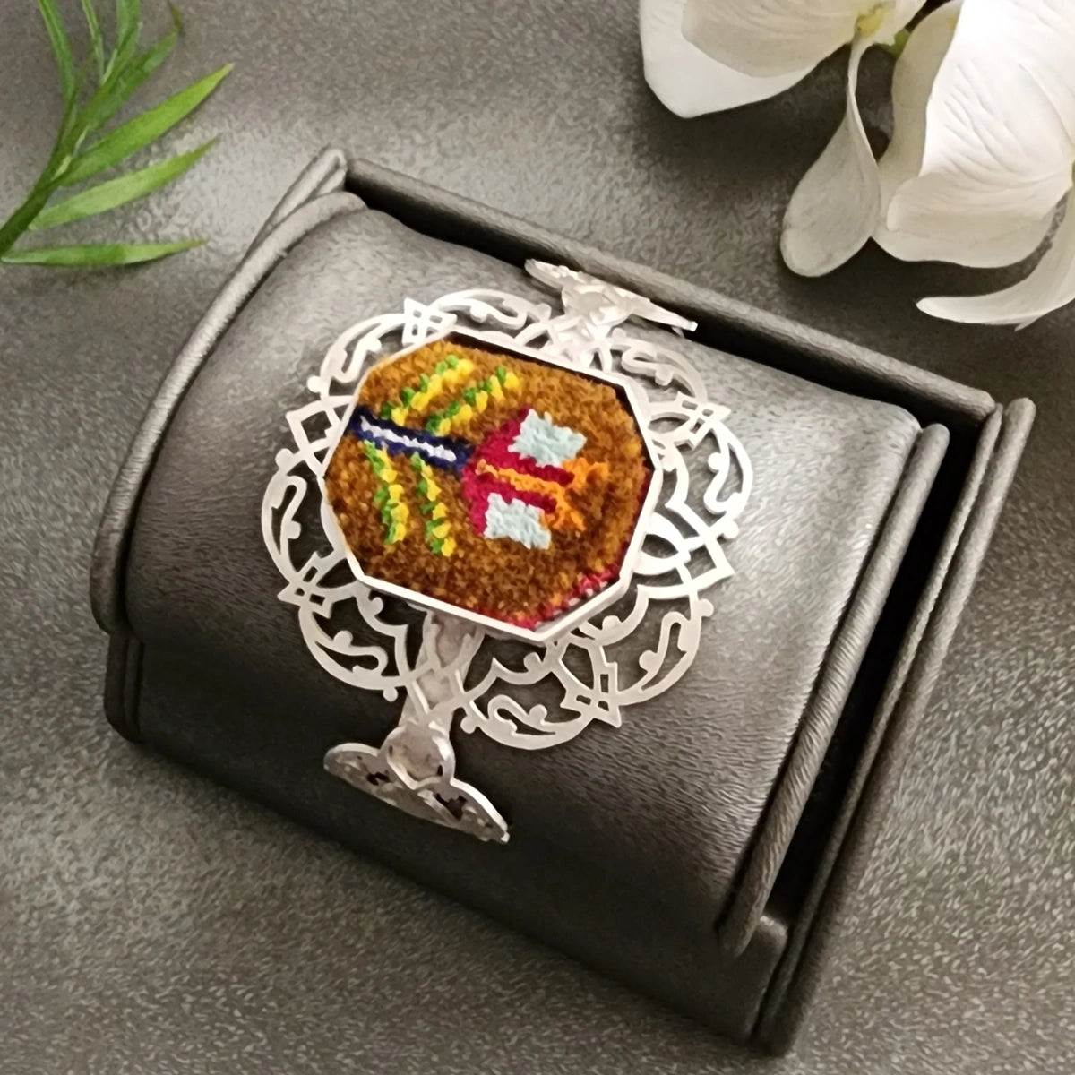 handmade silver bracelet with intricate openwork and Silk handwoven Persian rug