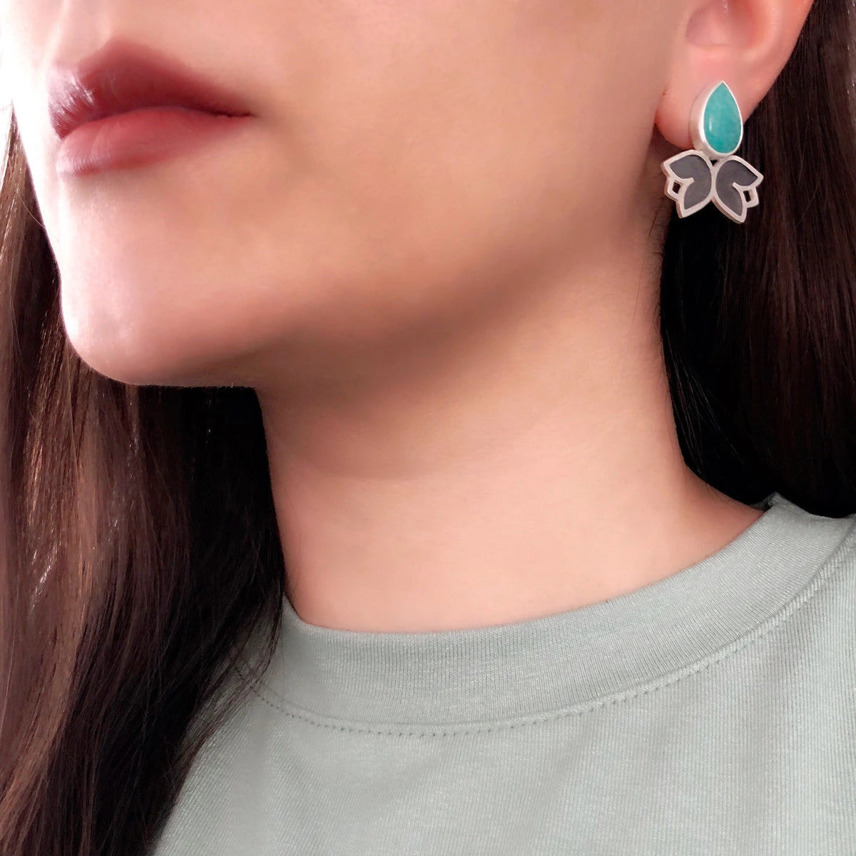 model wearing handmade mismatched stud earrings decorated with two flowers and teardrop amazonite