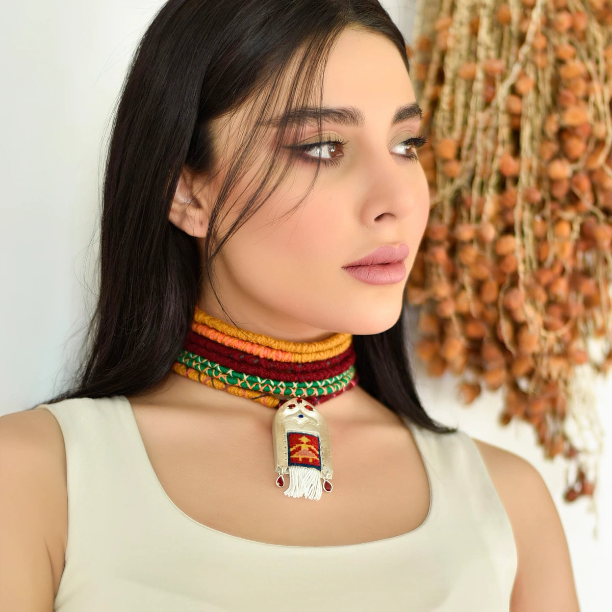 model wearing handmade silver necklace with Persian kilim inspired merino rug framed with silver decorations