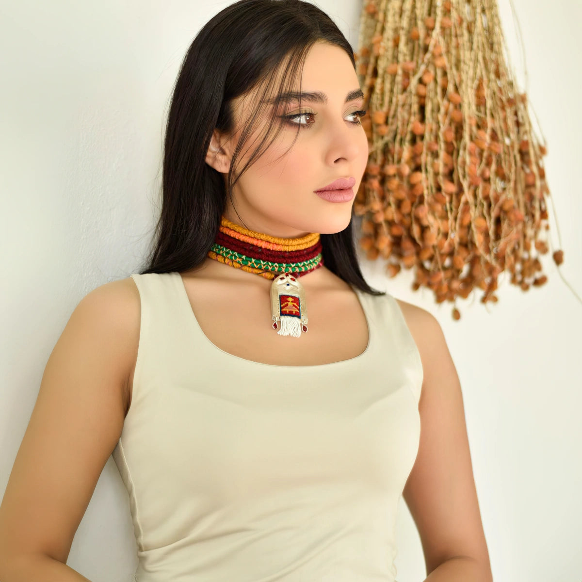 model wearing handmade silver necklace with Persian kilim inspired merino rug framed with silver decorations