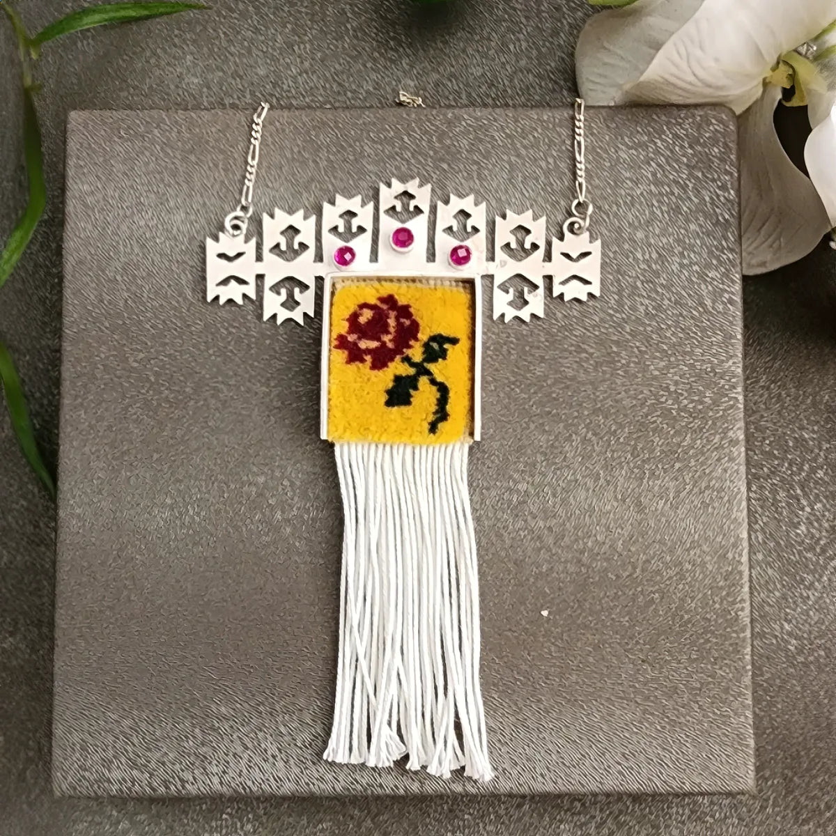 handmade statement necklace decorated with handwoven wool rug in yellow color with a red rose pattern and tassels hanging