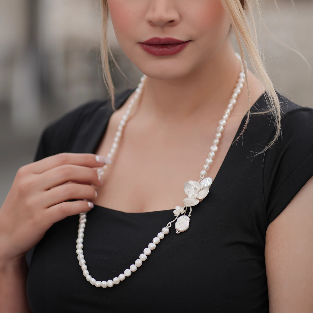 model wearing handmade silver matinee opera pearl necklace with silver orchids
