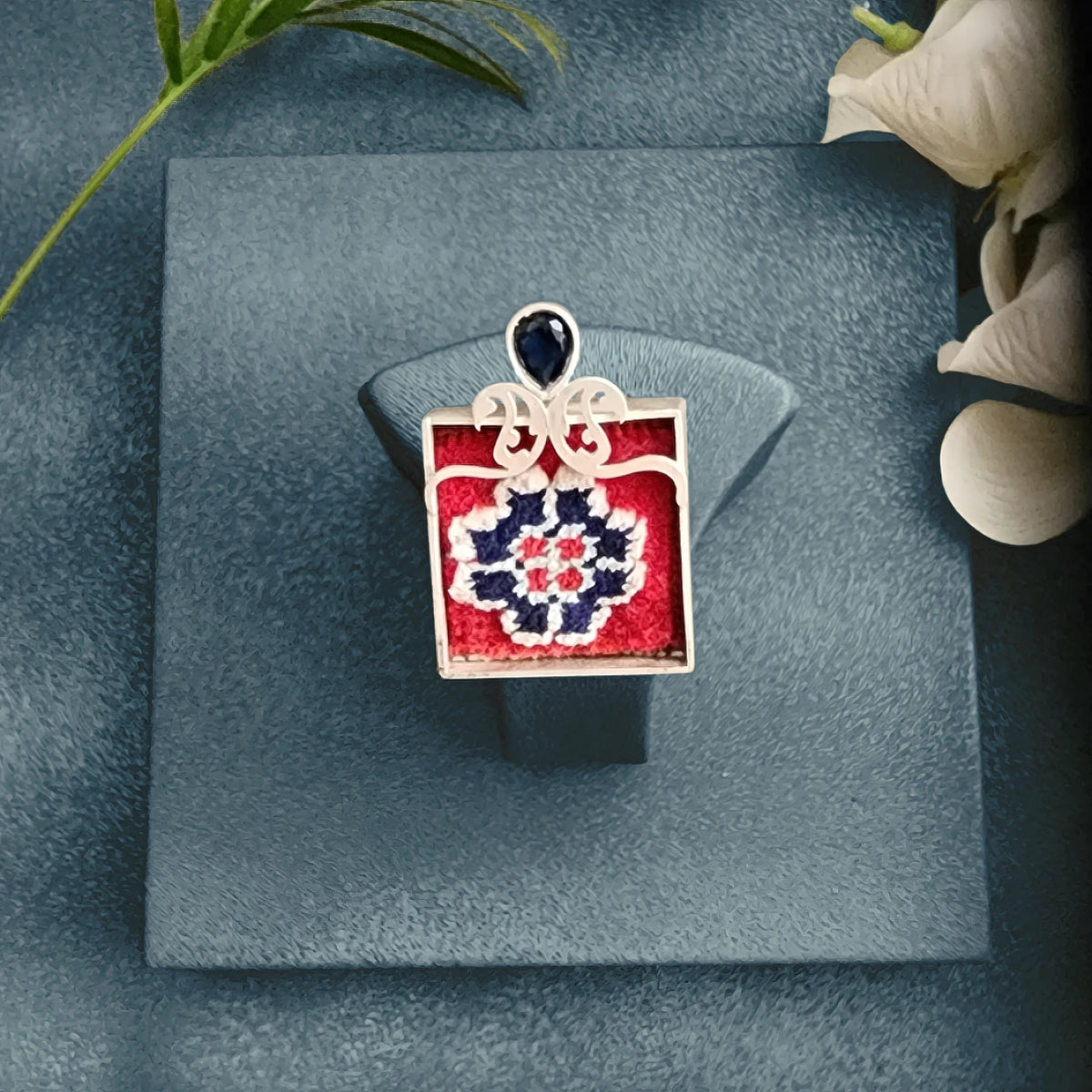 model wearing handmade silver and Persian rug statement ring with openwork paisley pattern and blue cubic zirconia