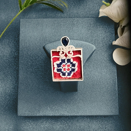 model wearing handmade silver and Persian rug statement ring with openwork paisley pattern and blue cubic zirconia