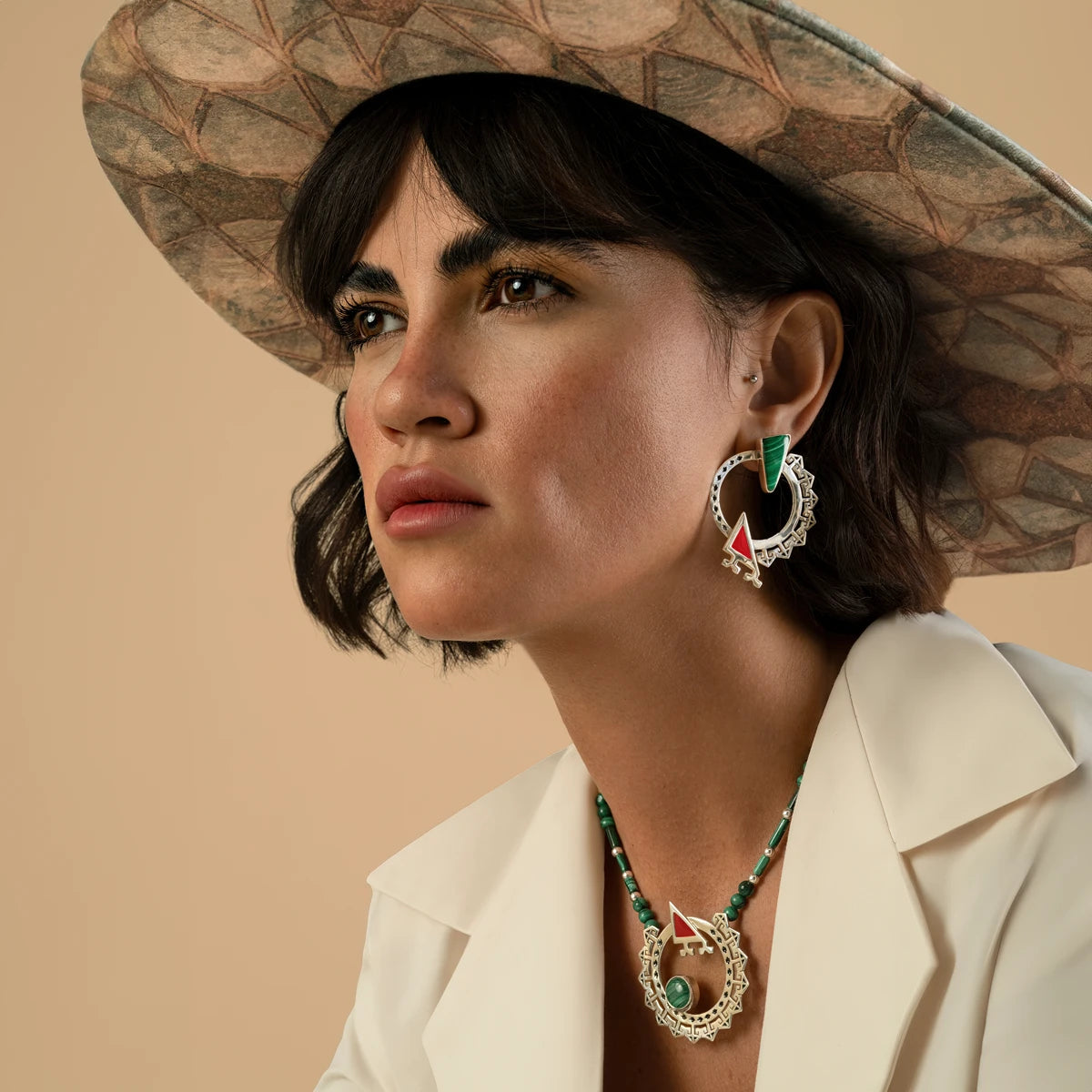 model wearing handmade ornate silver circle statement earrings and necklace with malachite and red cold enamel details