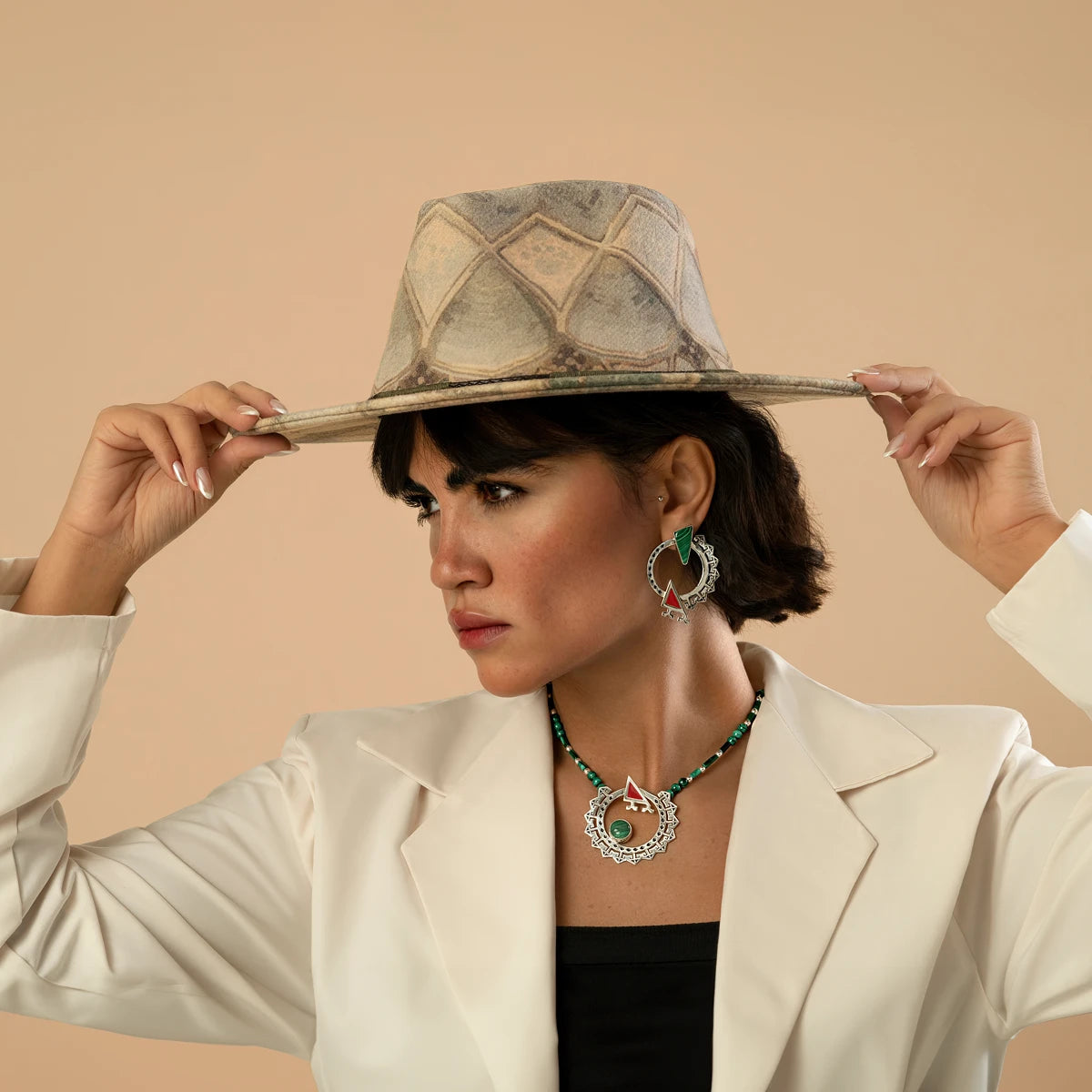 model wearing handmade ornate silver circle statement earrings and necklace with malachite and red cold enamel details