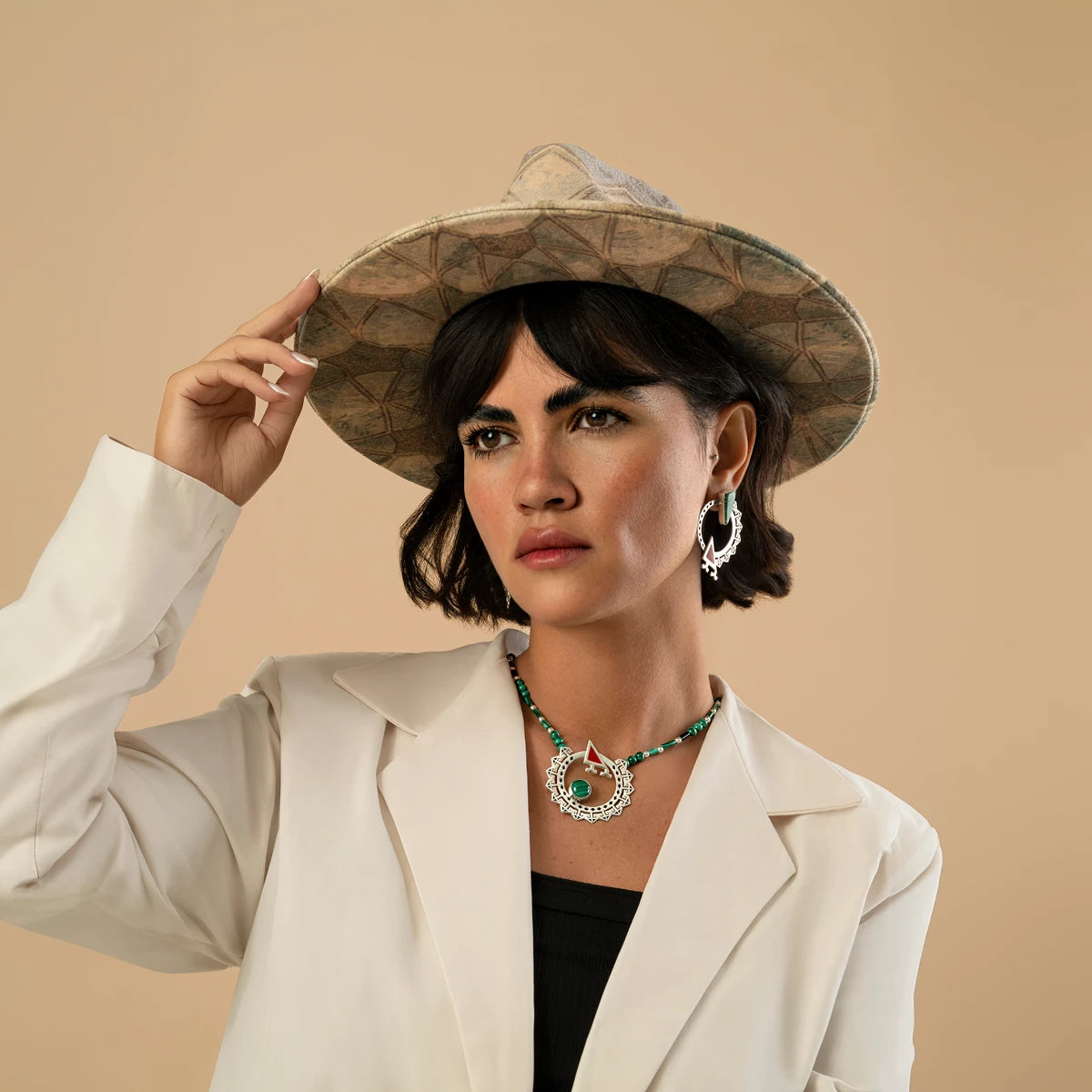 model wearing handmade ornate silver circle statement earrings and necklace with malachite and red cold enamel details