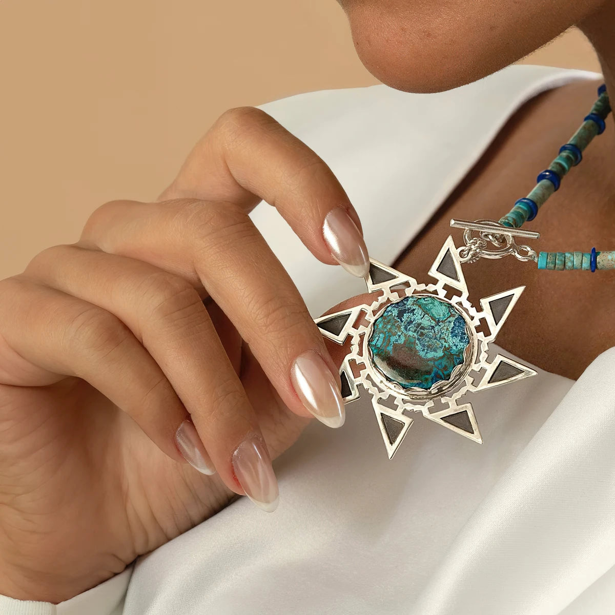 model wearing handmade star-shaped silver necklace with shuttukite, lapis lazuli and African Turquoise