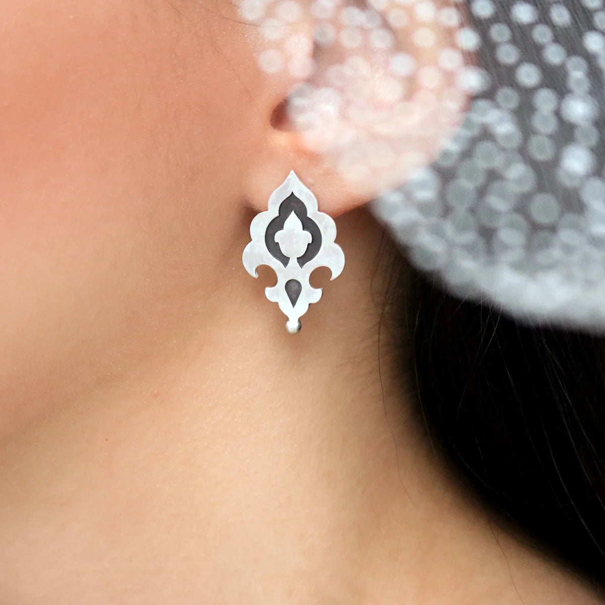 model wearing flower bud handmade silver stud earrings