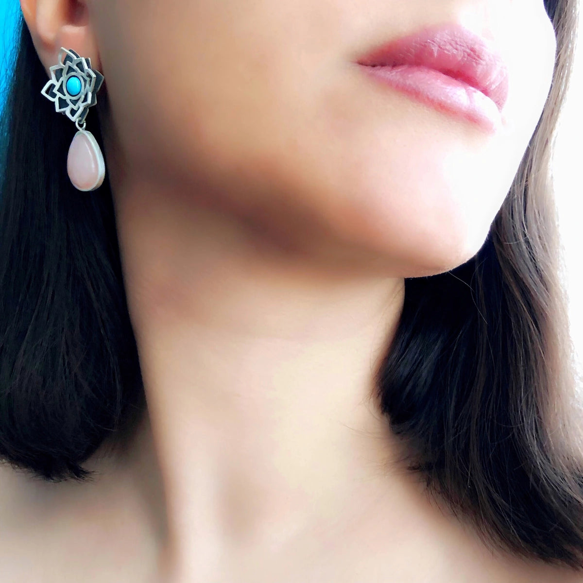 model wearing handmade geometric silver stud earrings with turquoise and amethyst