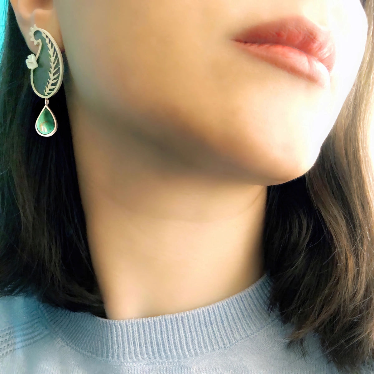 model wearing handmade silver mismatched stud earrings with amethyst, turquoise and mother of pearl