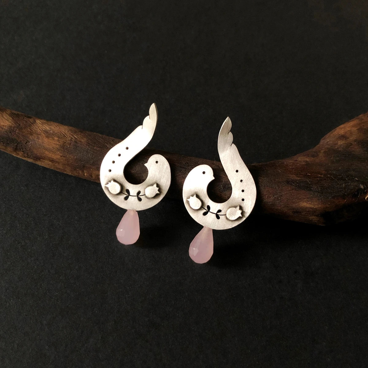 handmade silver stud earrings in the shape of a bird with rose quartz