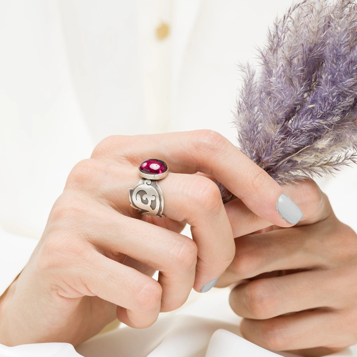 model wearing handmade silver statement ring decorated with oval ruby