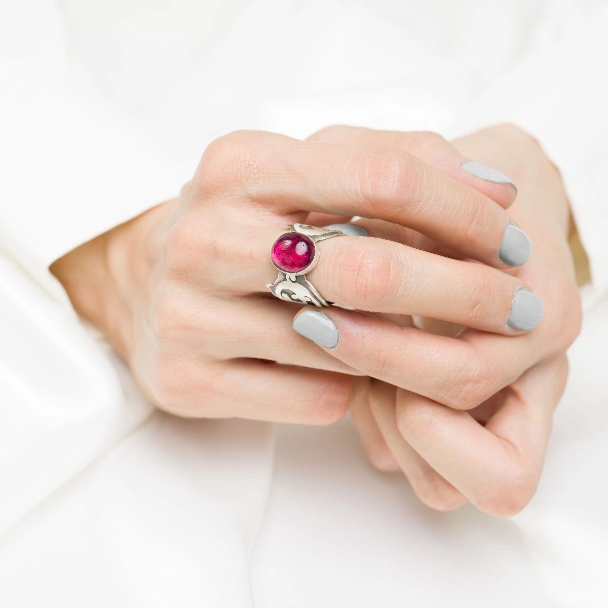 model wearing handmade silver statement ring decorated with oval ruby