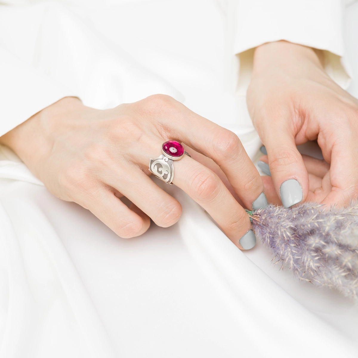 model wearing handmade silver statement ring decorated with oval ruby