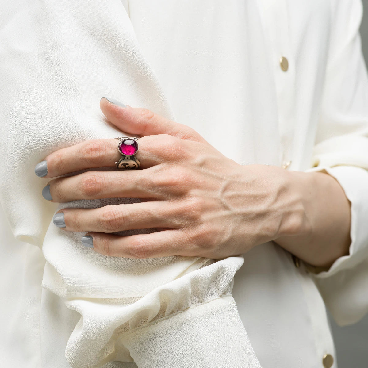 model wearing handmade silver statement ring decorated with red oval ruby