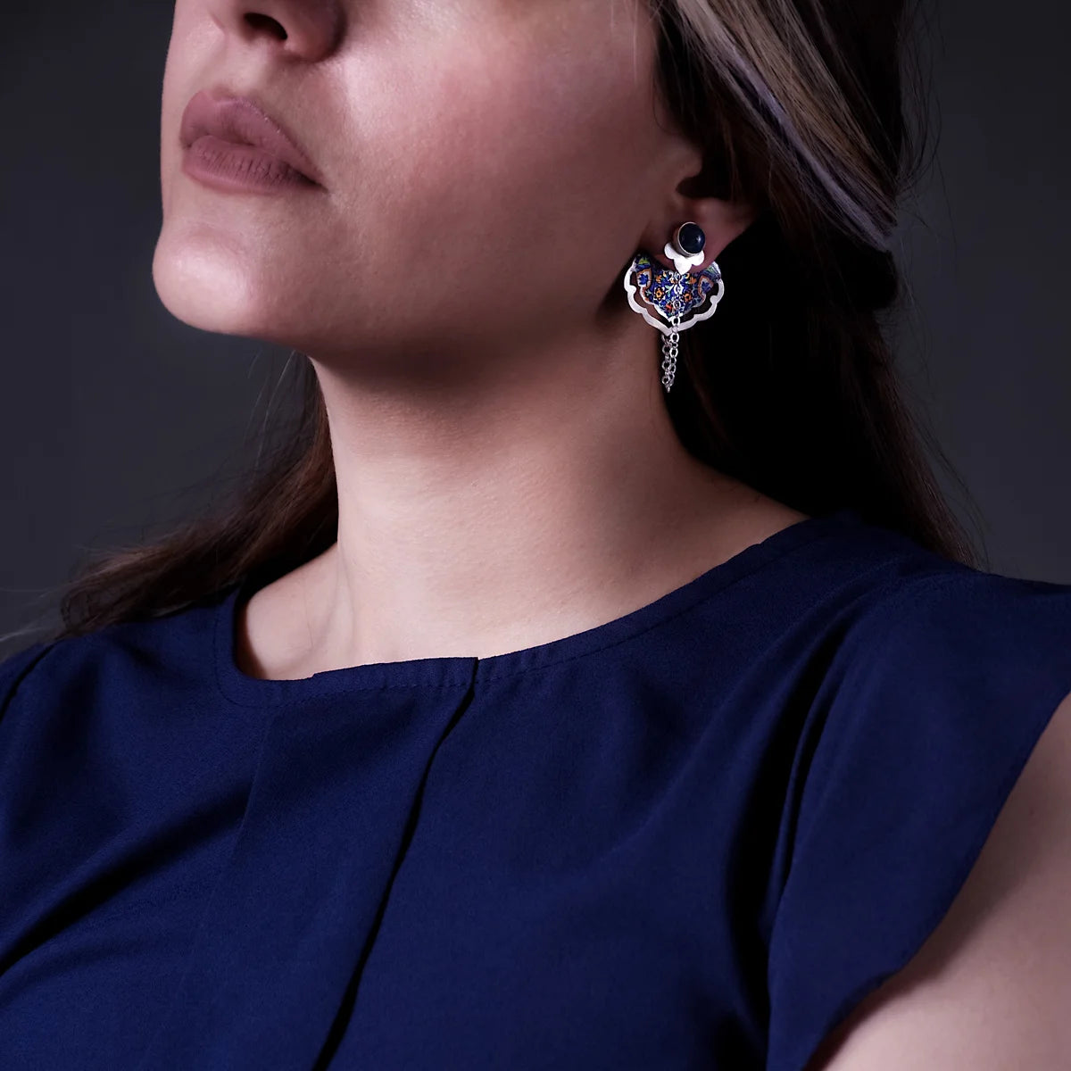 model wearing handmade silver ear jacket and dangle earrings adorned with lapis lazuli and floral patterns