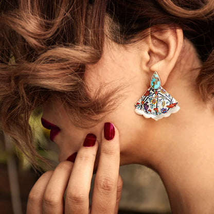 model wearing handmade silver statement earrings with turquoise and colorful patterns of birds and flowers