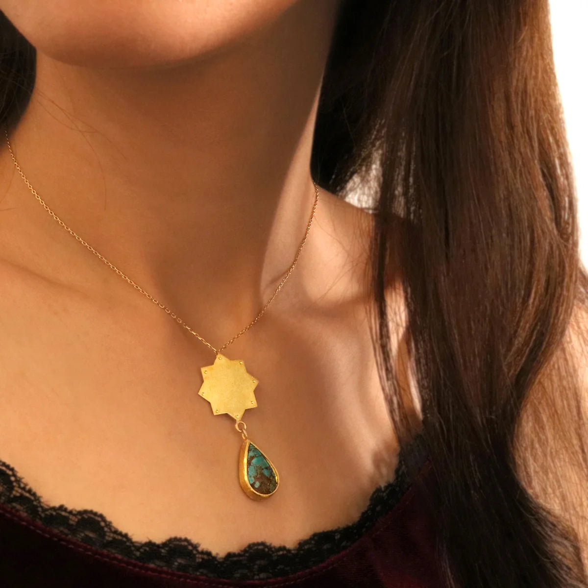 model wearing star shaped handmade gold plated silver pendant necklace with tear drop turquoise