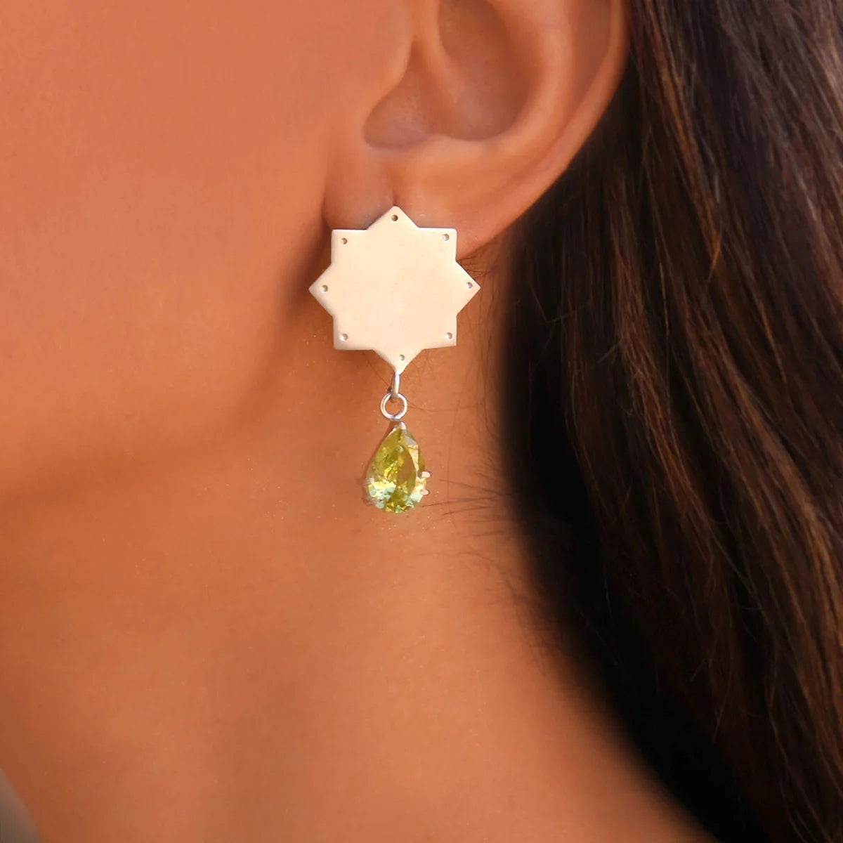 model wearing handmade silver mismatched star shaped  stud dangle earrings with yellow cubic zirconia