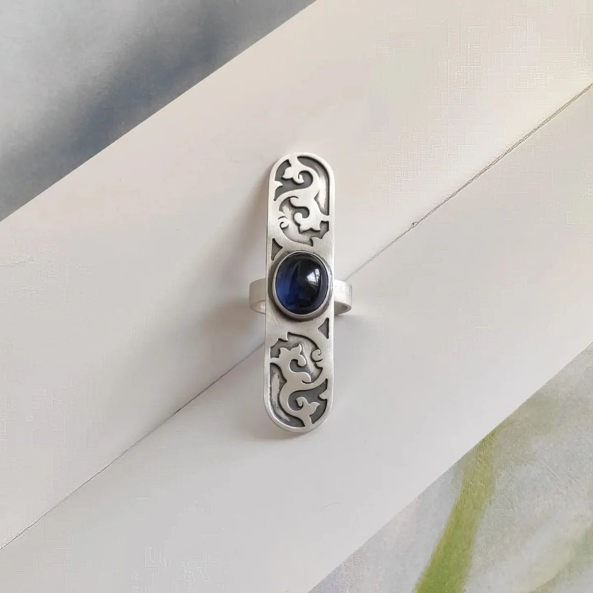 handmade oxidized silver statement ring with floral pattern and blue sapphire