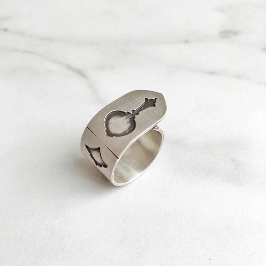 handmade oxidized silver statement ring with musical instrument shapes indented 