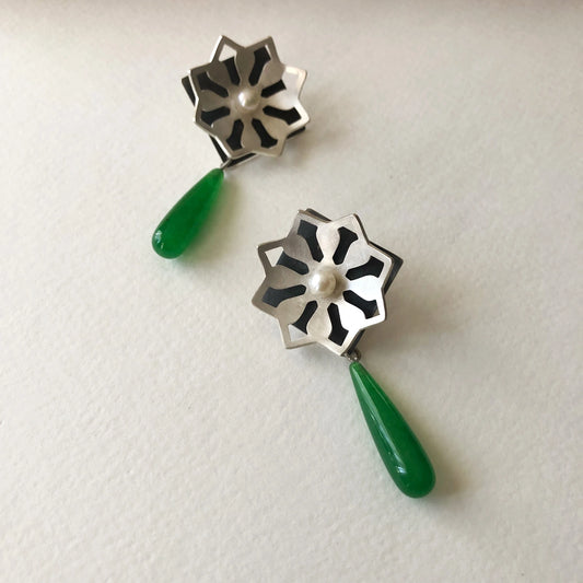 Pair of earrings with silver star design and green teardrop crystals and pearl