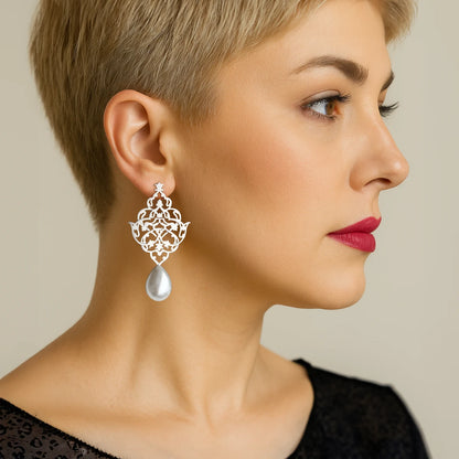 model wearing handmade silver lattice earrings with faux pearl teardrops and openwork floral arabesque design