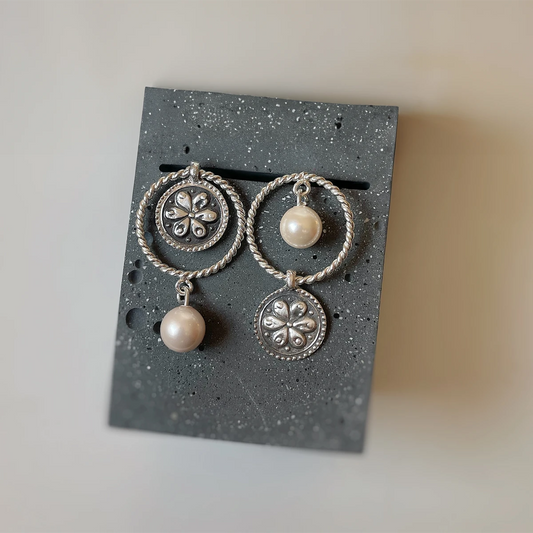 Handmade mismatched silver dangle earrings with rope-textured circles, faux pearls, and oxidized floral medallion design