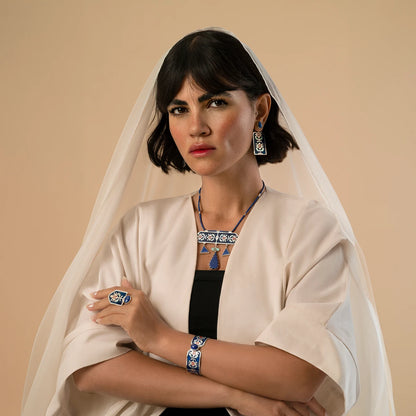 model wearing  handmade statement silver jewelry set with geometric patterns and decorated with blue enamel and red accents, lapis lazuli and turquoise.
