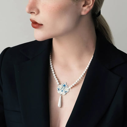 model wearing handmade silver and enamel necklace with shimmering white shell beads