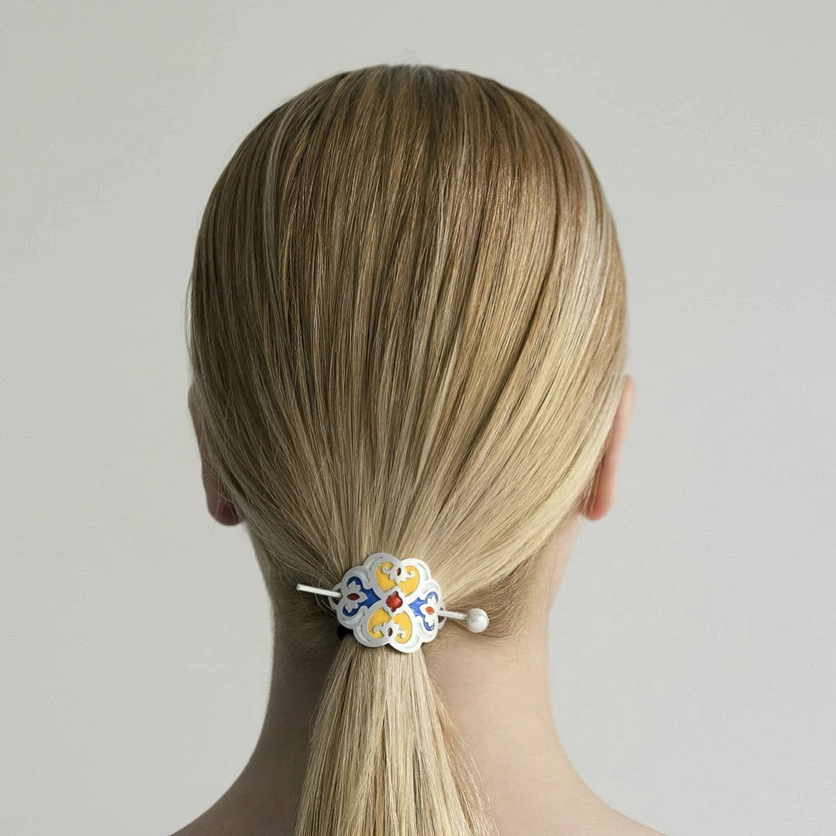 model wearing handmade silver stick barrette with yellow, red and blue enamel and pearl