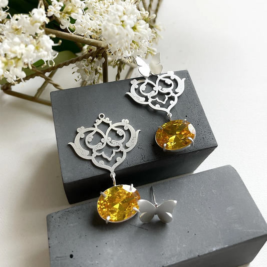 convertible sterling silver earrings with butterfly studs and detachable floral openwork panels featuring oval yellow crystal drops; two-way asymmetrical design