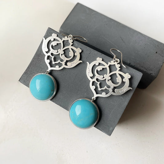 Handmade silver dangle earrings with Persian-inspired openwork and round turquoise stones.