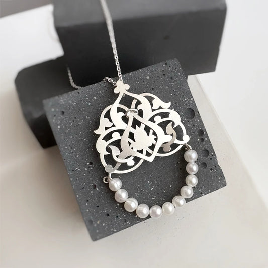 Handmade silver lattice pendant with interwoven floral design and natural cultured pearl arc
